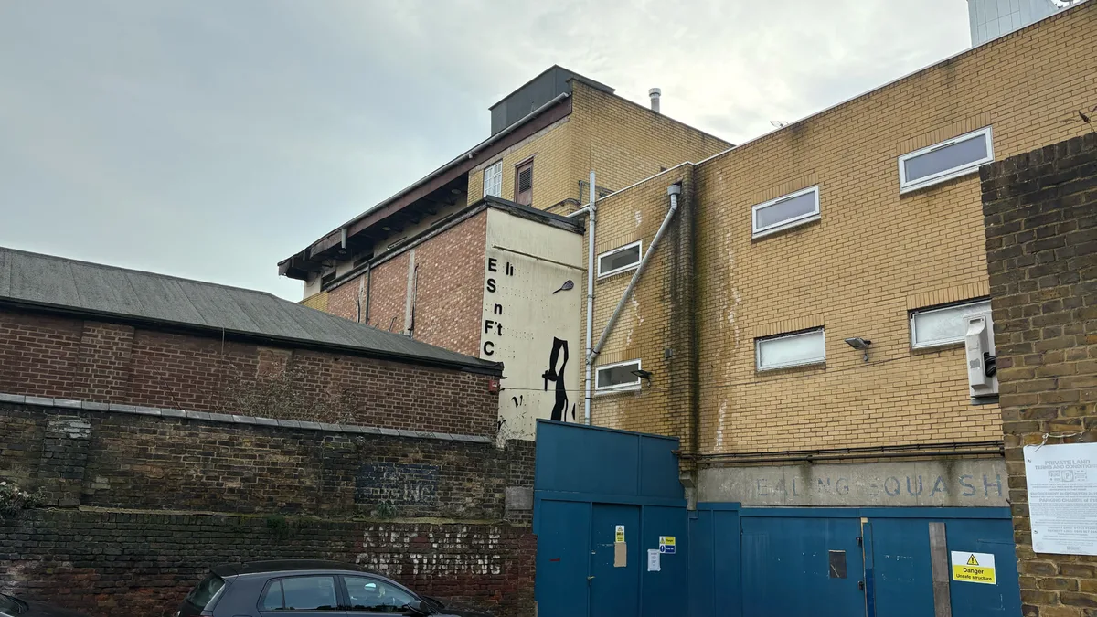 The vacant Ealing Squash club building at 41 Haven Green, behind The Broadway, with its name still over the boarded entrance.