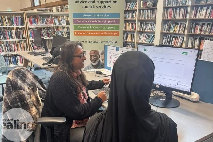 A member of council staff helps a resident at the community hub in Acton Library. The picture is not of the Greenford hub.